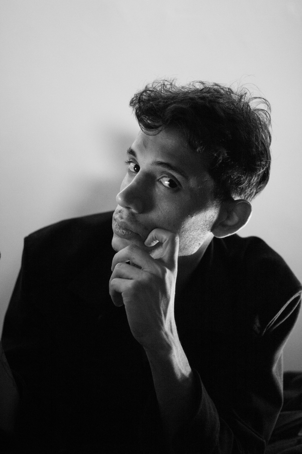 Black and white portrait of a man resting his chin on his hand
