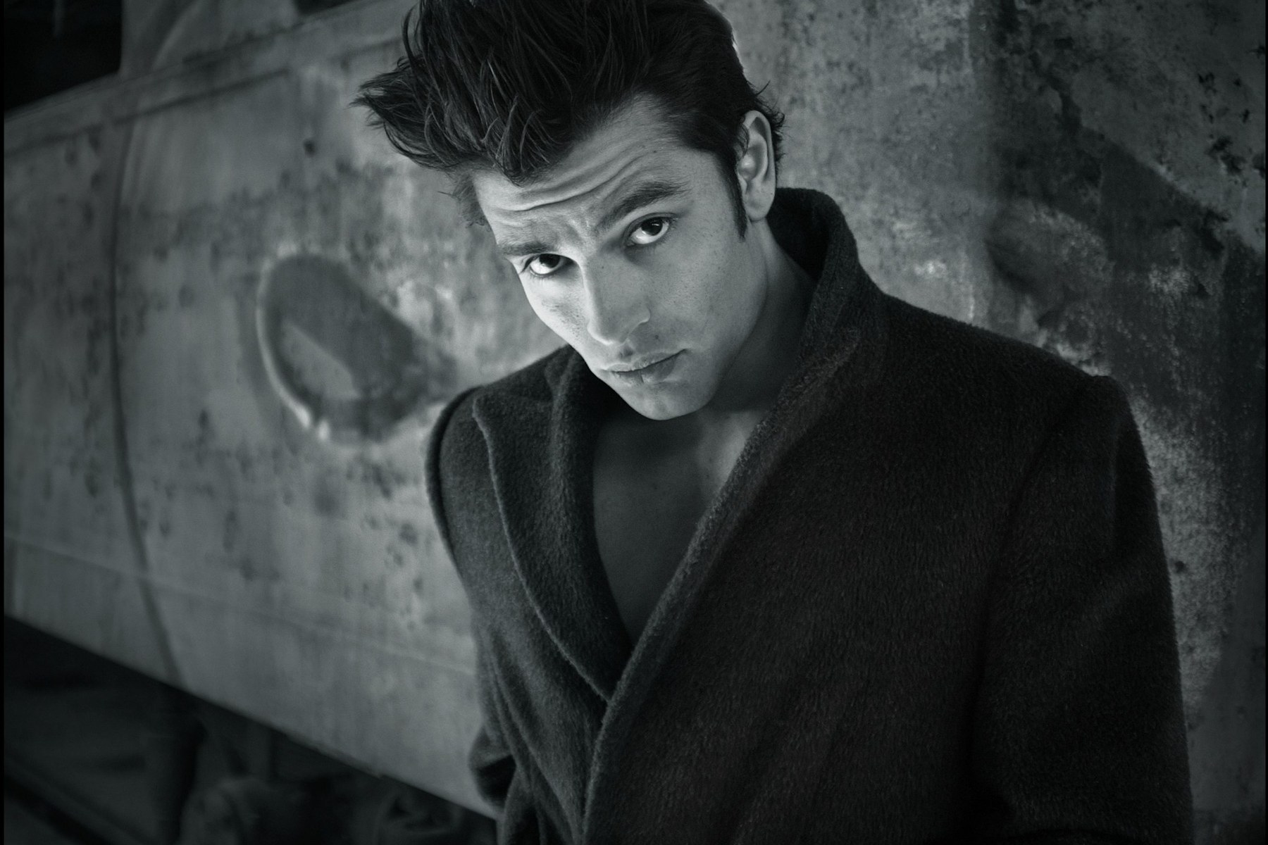 Black and white menswear outerwear portrait of a man in a dark coat